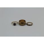 Three 9ct gold rings, one a band, size Q, one an emerald, diamond channel set ring ( one emerald