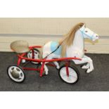 A circa 1950's Tri-ang childs pedal operated horse tricycle with galloping legs, in white blue and