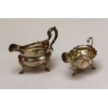 Two sterling silver sauce boats. The first a William IV footed sauce boot with scallop and hoof