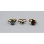 Three 9ct gold stone set rings, one a garnet cluster, size M 11/2, a topaz and diamond cluster, size