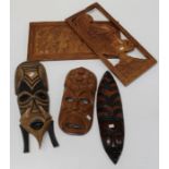 Three 20th century touristware Tribal masks, the largest 56cm together with two figural relief
