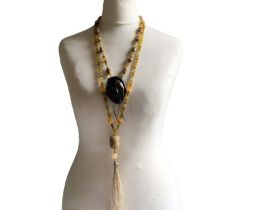 Two Chinese, hand knotted agate necklaces in the flapper style. One terminates with a carved