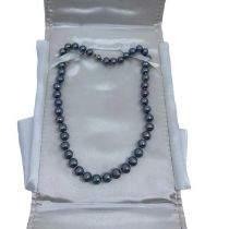 A single strand black pearl necklace in presentation box by Catherine best. The necklace has a