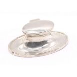 A George V oval shaped silver ink well with hinged top and glass liner, hallmarked Birmingham, 1924,