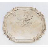 A George V silver salver, square shaped with canted raised corners, presentation inscription to
