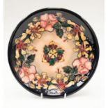 Moorcroft: A Dog Rose patterned plate, marked and signed to underneath, approx. 26cm diameter.
