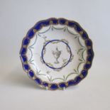 A Chelsea Derby Plate, decorated with an Urn and green garlands to the centre with Cobalt blue