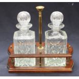 A mid 20th Century mahogany two decanter tantalus, with brass carrying pole