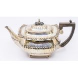 A Georgian style silver teapot, with gadroon and scroll cast apron, the body fluted lower section on