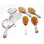 A collection of English silver dressing mirrors and brushes to include; two silver backed mirrors,
