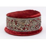 An Edwardian embossed silver mounted red velvet circular jewellery box and cover, the sides with