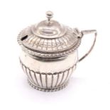 A Victorian silver mustard pot with gadrooned body, angular handle and ball finial to hinged lid,