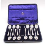 A  set of twelve Edwardian silver teaspoons with matching sugar nips, with engraved floral design