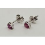 A pair of 18ct. white gold ruby stud earrings, each prong set single mixed oval cut ruby. (gross