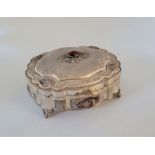 A baroque silver box, having lobed side with textured panels and applied floral decoration, the