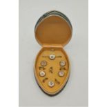 A set of yellow metal mounted mother of pearl dress shirt buttons, five buttons with fastenings