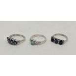 Three silver rings set various gemstones, to include: a silver, emerald and white topaz set ring,