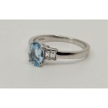 An 18ct. white gold aquamarine and diamond ring, set mixed oval cut aquamarine to centre with two