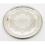 An Edwardian circular three footed presentation salver, with engraved floral and foliage design