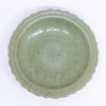 A Chinese celadon porcelain bracketed circular dish, Ming Dynasty (15th Century), set with central