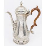 A George III silver coffee pot, baluster shaped engraved with scrolling foliage, the spout with