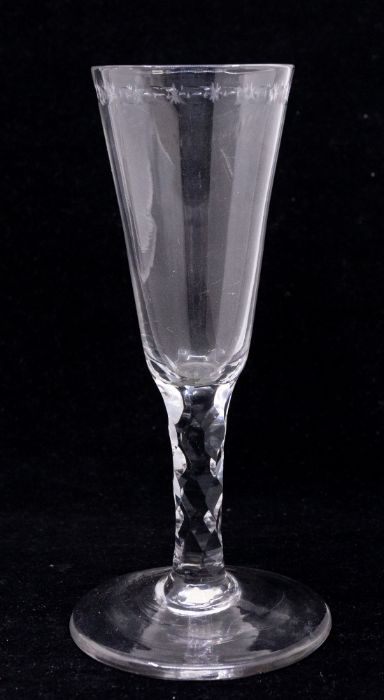 An 18th Century wine or champagne flute, the bowl with a band of etched star and oval cut out