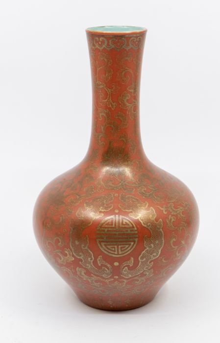 A Chinese Qianlong bottle vase, the red ground decorated with Chinese circle motifs within profuse