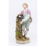 A Meissen figure of a young man, 'Freedom', collecting birds' eggs in his hat and leaning on a
