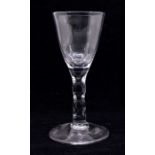 An 18th Century wine glass, the bowl with facet cut sections to lower bowl, facet cut stem, on