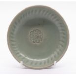A small celadon dish, Sawankholok, Thailand, 15th/16th Century, with central impressed florette