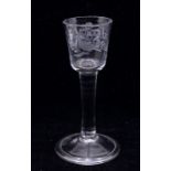 An 18th Century wine glass, the bowl engraved with a perched bird, a large flower and foliage, on