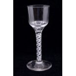 A mid 18th Century opaque twist wine glass, ogee bowl resting on white spiral cable air twist
