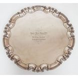 An Edwardian large silver salver, raised cut border on three scroll feet, the centre with