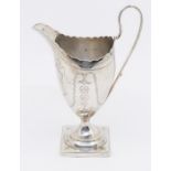 A George III silver helmet shaped cream, bright cut engraved decoration and vacant cartouche, on