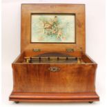 An early 20th century Symphonium, within a walnut veneered mahogany case, printed cherub design with