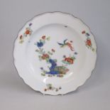 A Meissen plate, painted in Kakiemon style with a bird in flight over flowers and rockwork, Date