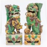 A pair of Chinese egg and spinach glazed Dogs of Fo incense (jos stick) holders, Qing Dynasty (