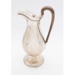 A George III silver pear shaped claret jug, beaded border, fruitwood handle with acanthus terminals,