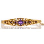 An ornate Victorian style hinged bangle. In 9ct gold and set with amethyst and seed pearls. With