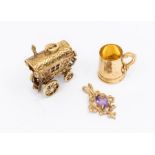 Three 9ct gold charms. Featuring an articulated Gypsy caravan, which opens to reveal an occupant