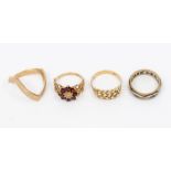 A collection of ladies rings. Featuring a 9ct gold wishbone ring (size U); a garnet and diamond