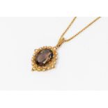 A 9ct gold smoky quartz and seed pearl set pendant, suspended from a box chain. Pendant drop