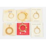 A collection of 9ct gold coin mounts. Vintage dead stock in original packaging. Comprising a