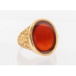 A 9ct gold Carnelian set signet ring with textured shoulders. Size V. Gross weight approximately