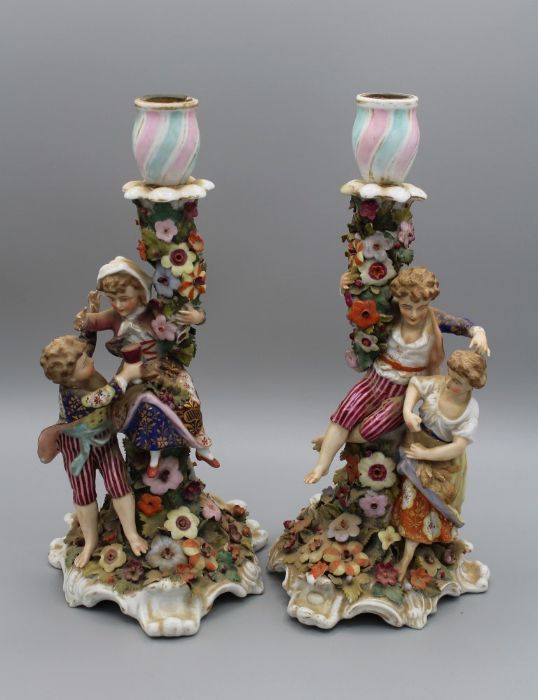 A pair of 19th century Derby porcelain figural candlesticks, each modelled with a young boy and girl