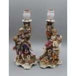 A pair of 19th century Derby porcelain figural candlesticks, each modelled with a young boy and girl