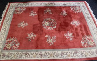 A 20th century Chinese wool carpet, woven with pastel floral sprigs on a peach and cream ground