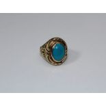 A 9ct gold ring, set oval turquoise, to a heavily textured shank, 10gm gross weight, size T