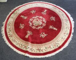A 20th century Chinese wool rug, woven with central dragon motif on a claret ground with cream Greek