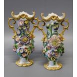 A pair of 19th century porcelain florally encrusted Rococo-form twin handled vases, richly decorated